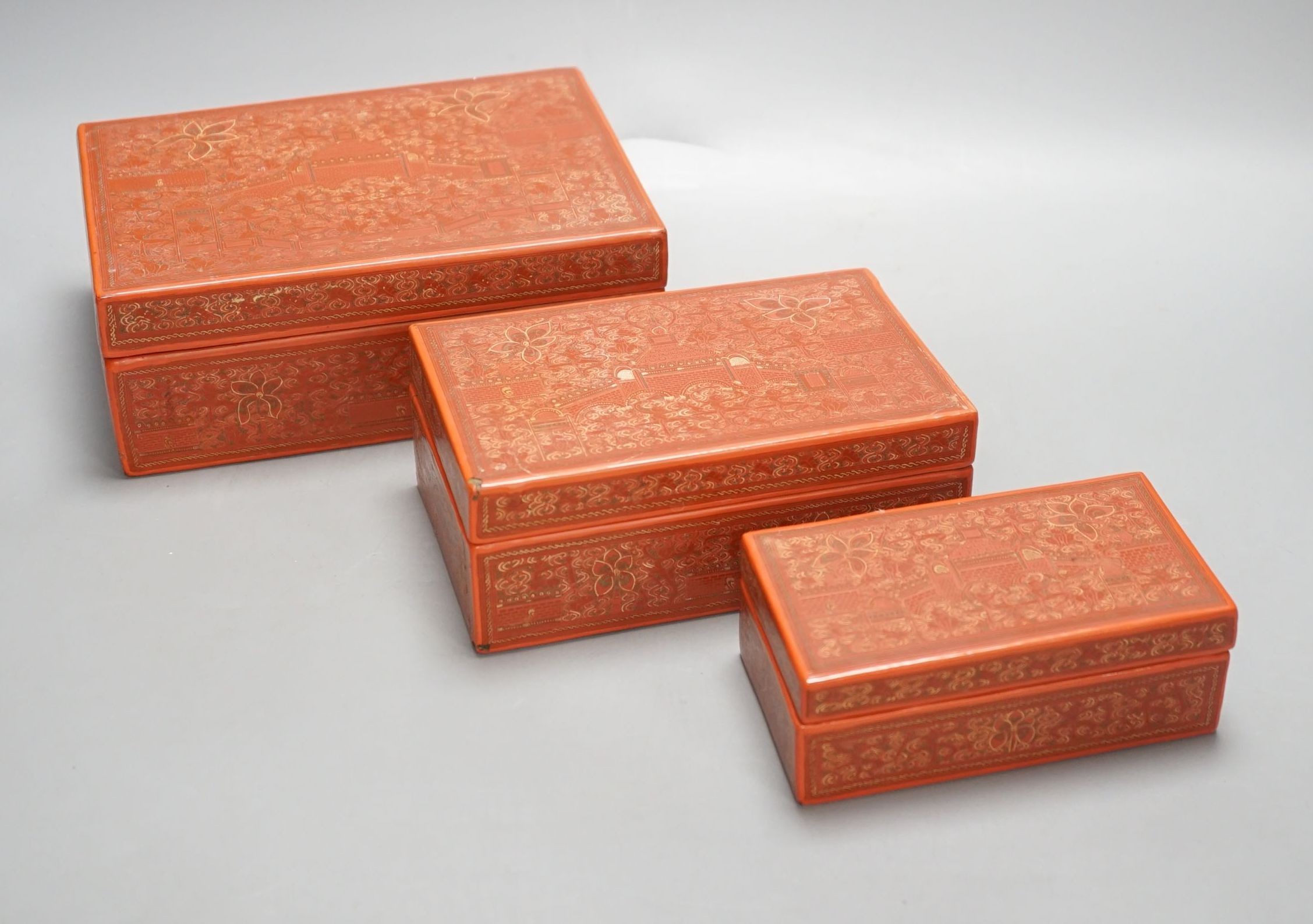 Three Burmese red lacquer graduated boxes, largest 21 cms wide.